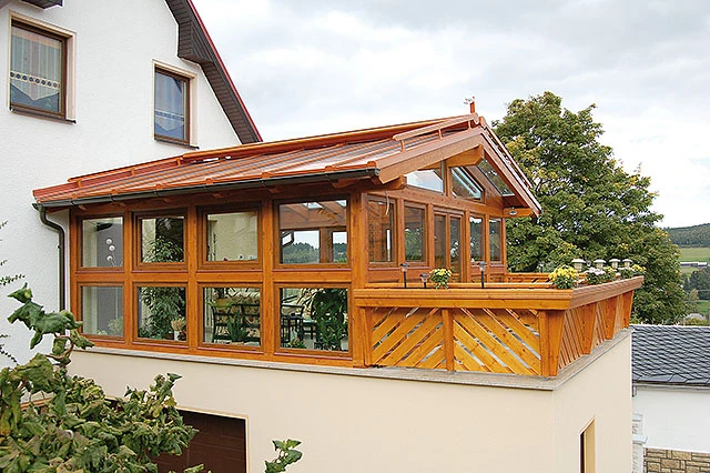 Kombinierter Holz-Aluminium-Wintergarten in Markneukirchen auf einer überdachten Terrasse mit Holzgeländer